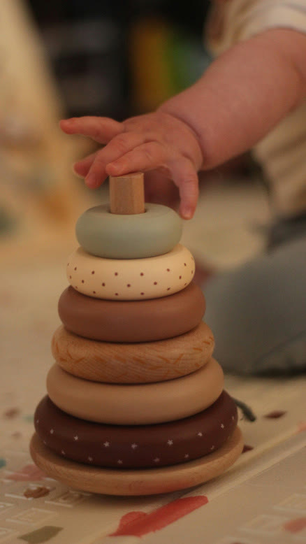 La mano de un bebé sobre un apilable de madera